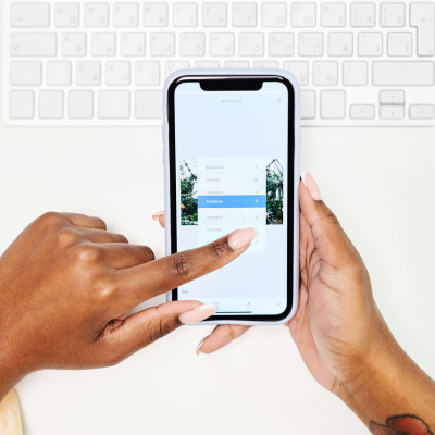 A woman's hands editing images on her phone.