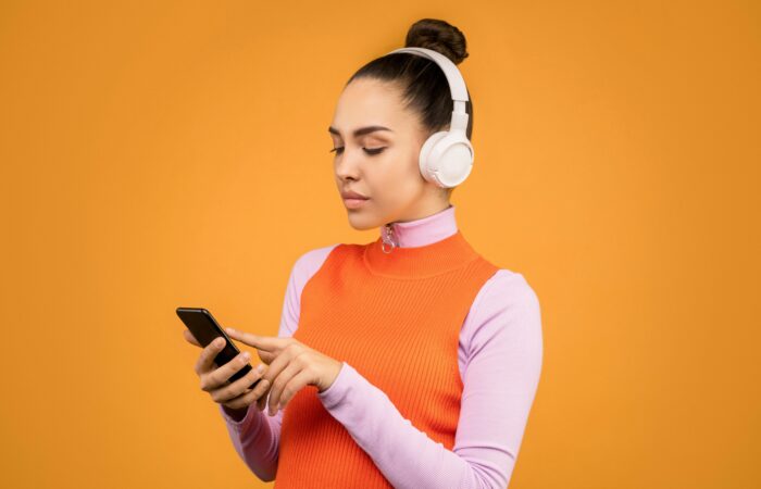 Woman wearing headphones scrolling on her phone