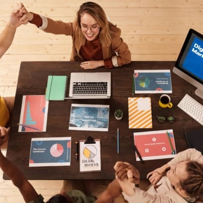 Team sitting around a table discussing 7Ps of marketing