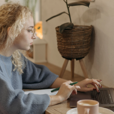 woman with curly blonde hair working on a laptop