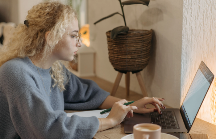 woman with curly blonde hair working on a laptop