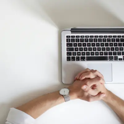 Hands clasped over a keyboard from above
